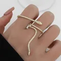 Schlangenförmiger Wickelring in Goldoptik mit weißen funkelnden Kristallen am Finger - 14K Gold