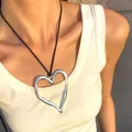 Pendentif cœur argenté irrégulier artistique avec cordon noir porté par un modèle - Coeur Argent Évidé (Cordon Noir)