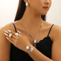 Barockes Perlen-Schmuckset mit silberner Halskette und Ohrringen an einem Model - Armreif Ring Halskette Ohrringe / Silber