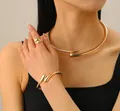 Polished gold jewelry set with open bangle and necklace on model in warm studio light - Neck Collar + Bangle + Ring Three-Piece Set / Gold