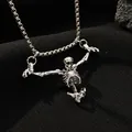 Macro shot of silver gothic skeleton pendant on a box chain over black textured fabric - Hanging Skeleton Style (A-1373)