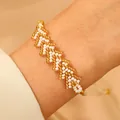 Detail eines handgefertigten Perlenarmbands mit goldenem und weißem Zickzack-Muster - Weiß (N-1048)