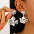 Pendientes de flores plateadas vintage con textura de metal cepillado puestos en modelo - Estilo Flor de Doble Capa Plateada (N-1013)