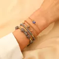 Detailed view of 5-piece gold and grey bead bracelet set with blue evil eye charm - 06 Gray (5-Strand Set/10760)