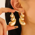 Pendientes de gota dorados de varias capas con diseño de ondas mostrados en la oreja real - Estilo de Ola de Triple Capa Dorado (3401)