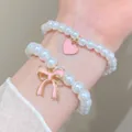 Elegant pearl bracelets with pink enamel heart and bow charms on a gold base - Heart Bow Artificial Pearl Style / Pink (2623)