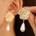 Detail of vintage gold flower earrings featuring elegant white teardrop pearl pendants - Floral Pearl (N-402)