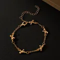 Elegante pulsera con dijes de lazo dorado y cierre de langosta ajustable en cuero negro - Pulsera con Lazo Dorado (N-1089)