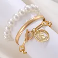 Three-piece gold bangle set with faux pearls and coin pendant on a white display stand - Gold (6297)