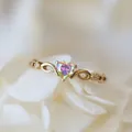 Golden ring with heart-shaped iridescent stone and infinity symbol on white petals - Gold Colorful Rhinestone