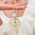 Dettaglio del ciondolo ad anello in finta giada con perla su collana in corda intrecciata indossata - Motivo Ambra Giallo Chiaro (N-121)
