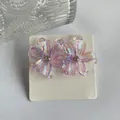 Y2K iridescent purple resin flower earrings with sparkling rhinestone center on white card - Light Purple