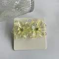 Y2K iridescent yellow resin flower earrings with central rhinestone on display card - Light Yellow