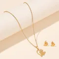 Detail shot of a golden stainless steel butterfly necklace and stud earrings set on a pedestal - Hollow Heart Butterfly (FX50) / Gold