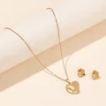 Detailed close-up of golden stainless steel heart jewelry set with love engraving - Asymmetric LOVE Heart (FX51) / Gold