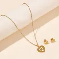 Detail view of heart-shaped pendant necklace and earrings set in polished gold finish - Double Layer Hollow Heart (FX46) / Gold