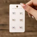 Vue détaillée de trois paires de boucles d'oreilles nœuds en résine irisée sur carte - Style Nœud Iridescent (Ensemble de 3 Paires) (FX846)