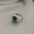 Detailed macro shot of an emerald cut green gemstone ring with halo zircon settings - Adjustable Open / Emerald
