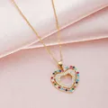 Collar de doble corazón dorado con circonitas de colores sobre satén rosa suave - Dorado