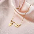 Golden paperclip necklace with heart pendant on pink silk, minimalist style - Gold
