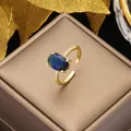 Dettaglio dell'anello regolabile dorato con gemma blu ovale e piccoli zirconi bianchi - Blu-Oro