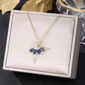 Collana ballerina dorata con zirconi blu scuro su un elegante portagioie in velluto - Blu