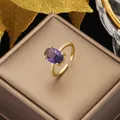 Dettaglio macro di anello dorato regolabile con gemma ovale viola e zirconi - Viola Oro