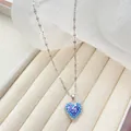 Detailaufnahme des Herzanhängers mit blauen Zirkon-Farbverlauf in einer Schmuckschatulle - Silber-Blau