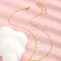 Detailed close-up of golden stainless steel petal chain with lobster clasp and tag - Gold