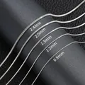 Catene a serpente in acciaio argento con larghezze da 0,9 mm a 2,4 mm su sfondo nero - Colore acciaio