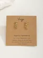 Boucles d'oreilles signe astrologique Vierge dorées sur carte de présentation kraft - Vierge-Or