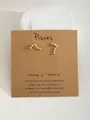 Orecchino a perno zodiaco Pesci dorato con zirconi su cartoncino regalo a tema - Pisces