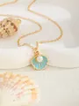 Détail d'un pendentif coquillage doré avec émail bleu et perle centrale sur une chaîne fine - Coquillage - Bleu
