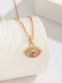 Gros plan détaillé d'un collier œil protecteur doré avec strass roses sur support blanc - Œil