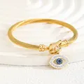 18K gold-plated twisted cable cuff bracelet featuring a sparkling crystal evil eye charm - Evil Eye Style