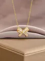 Gold bow necklace with pink zircon tassels and clear gemstones on a satin display - Golden Bow Style (1)