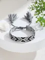 Detalle de pulsera tejida con patrón negro y gris y borlas ajustables en soporte blanco - Estilo de Textura de Flecha Negro Gris Blanco (22)