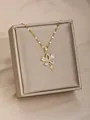 Collar dorado con colgante de mariposa en circonita y estrella sobre fondo de seda champán - Lazo de Zirconia en Lágrima (16)