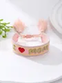 Vista detallada de la pulsera bordada rosa con texto dorado I Love Mom y borlas suaves - Estilo Bordado de Corazón I MOM Rosa (28)