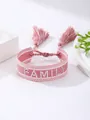 Primer plano de pulsera tejida rosa con bordado FAMILY blanco y detalles de borlas - Estilo Bordado de Puntos FAMILY Rosa Blanco (32)