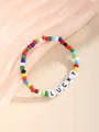 Makroaufnahme von buntem Boho-Perlenarmband mit Lucky-Buchstaben-Anhängern - Lucky Buchstaben Stil