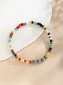 Makroaufnahme bunter Perlen und HOPE-Buchstabenanhänger auf einem Keramiktablett - HOPE