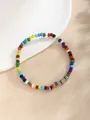Detalle macro de la pulsera de cuentas de colores BFF sobre fondo neutro con textura - BFF