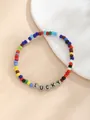 Makro-Detail des bunten Perlenarmbands mit LUCKY-Buchstaben auf beigem Hintergrund - LUCKY