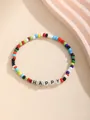 Primer plano de pulsera de cuentas coloridas con letras HAPPY sobre fondo amarillo - HAPPY