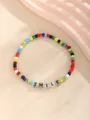 Nahaufnahme von buntem Perlenarmband mit SMILE-Buchstaben auf beigem Hintergrund - Lächeln