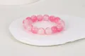 Detalle macro de pulsera de cuentas rosas redondas con textura sobre bandeja cerámica - Cuentas Floculentas Rosa Rojo (9-Blanco Rojo)