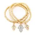 Detailansicht von drei goldenen Perlenarmbändern mit funkelnden Hamsa-Hand-Anhängern - Gold Hamsa Hand Stil (S84-SL05644-GD)