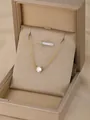Minimalist gold chain necklace featuring a single round zircon pendant in a beige gift box - Solitaire Necklace