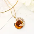 Dettaglio del ciondolo in cristallo ambrato sfaccettato con filigrana dorata e strass - Stile Oro Pietra Preziosa Champagne